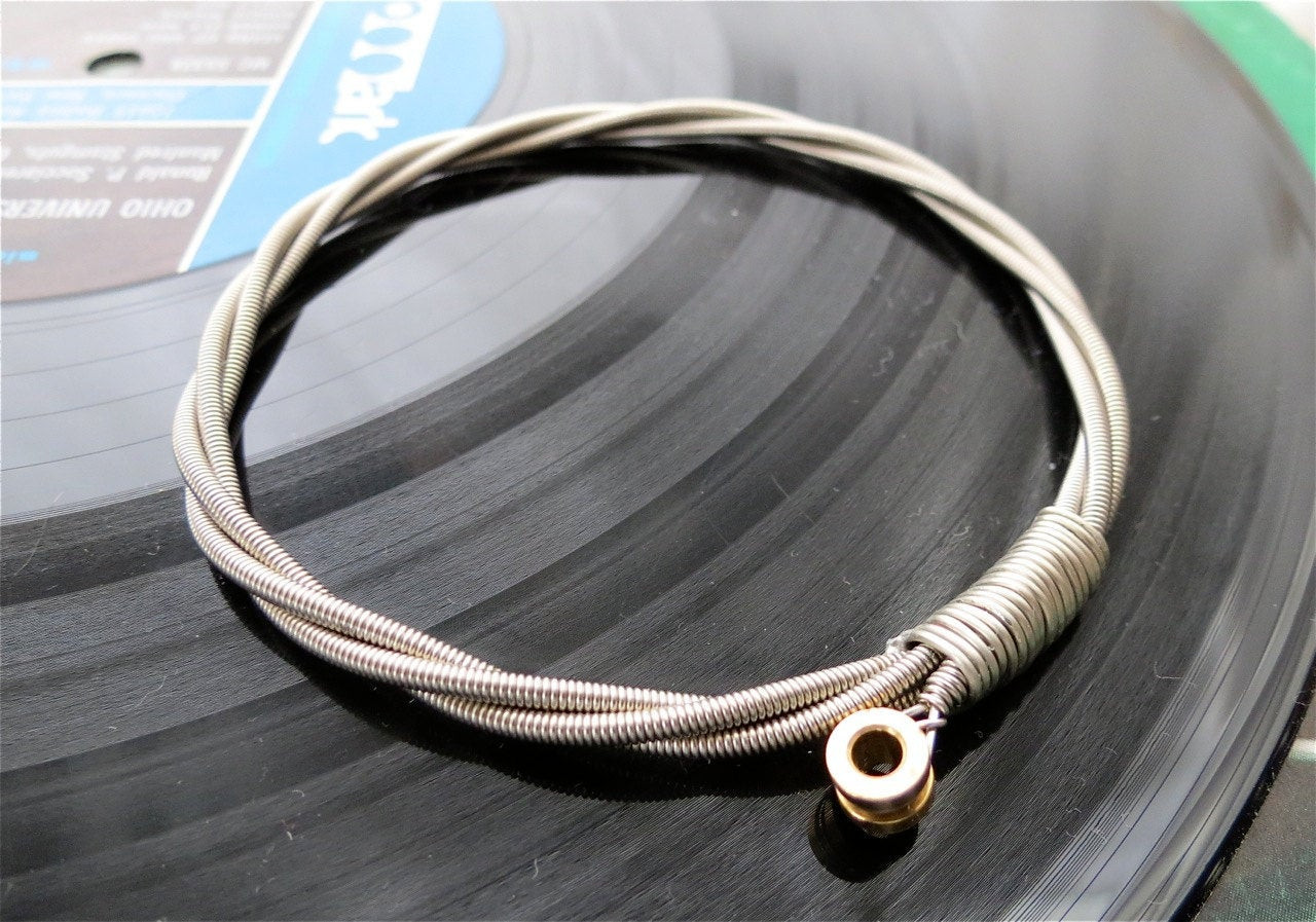 Guitar String Bracelet
 Recycled Bass Guitar String Bracelet silver colored with brass